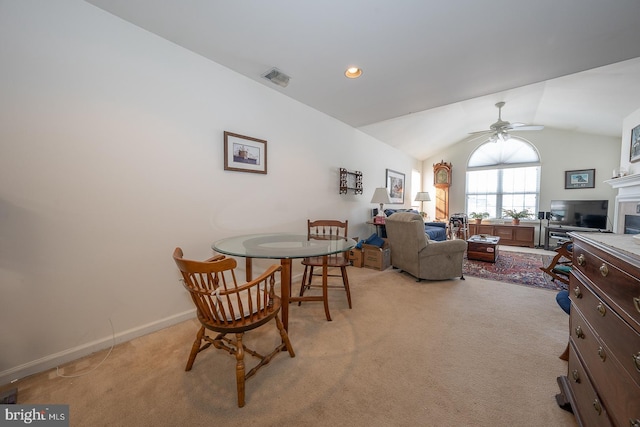 dining room featuring ceiling fan, light colored carpet, and lofted ceiling