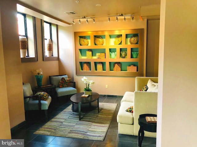 sitting room featuring rail lighting and dark tile patterned floors