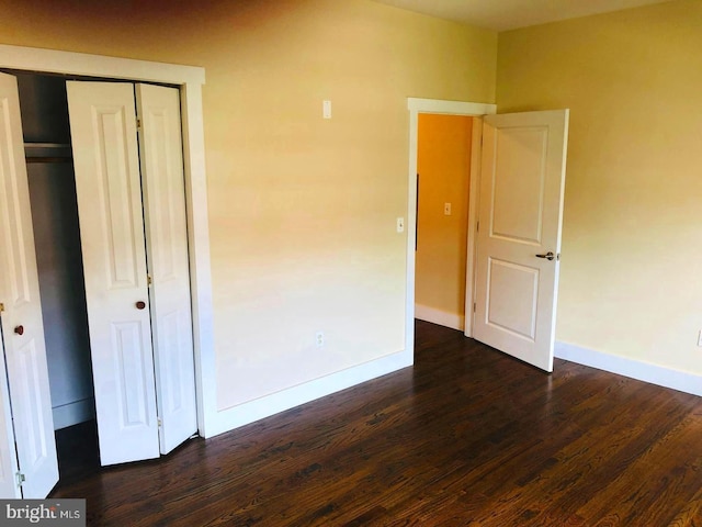 unfurnished bedroom featuring dark hardwood / wood-style flooring and a closet