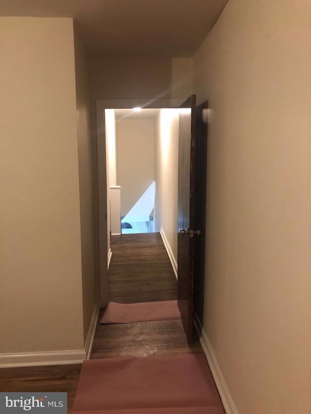 hallway with dark hardwood / wood-style flooring