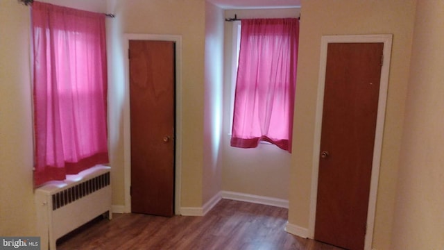 unfurnished bedroom with hardwood / wood-style floors and radiator