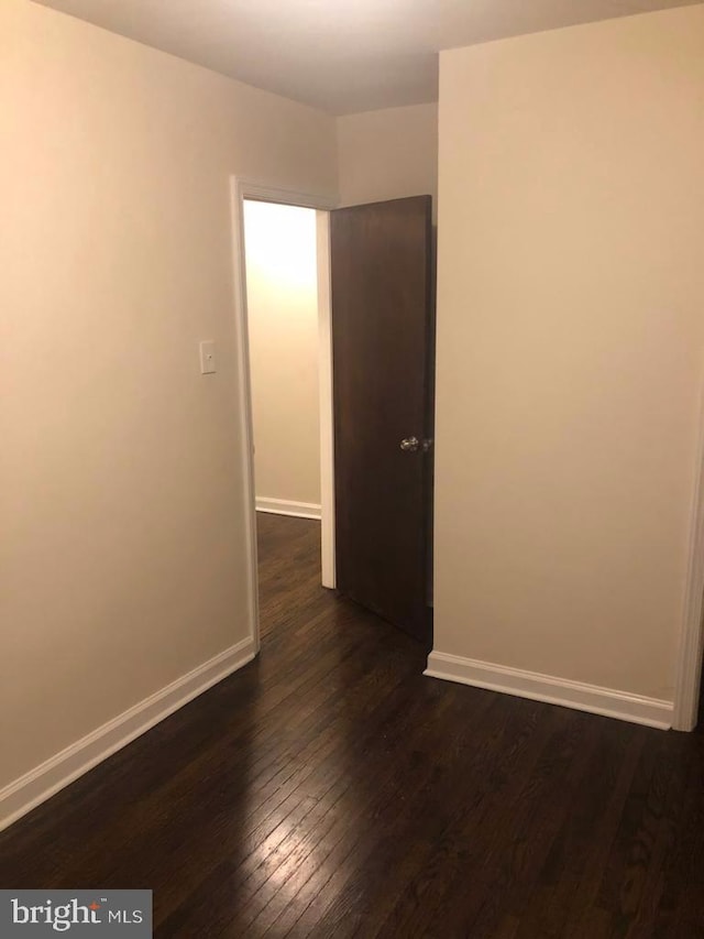 spare room with dark hardwood / wood-style floors