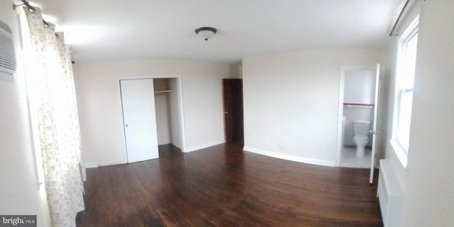 unfurnished bedroom featuring dark hardwood / wood-style floors and ensuite bathroom