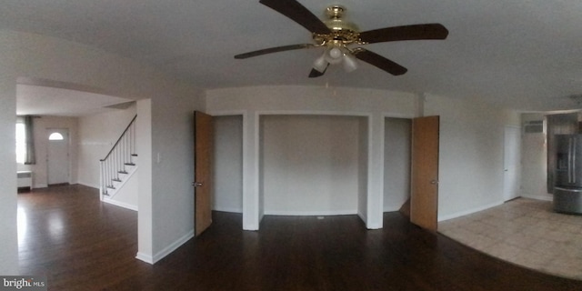 unfurnished living room with ceiling fan and dark hardwood / wood-style floors