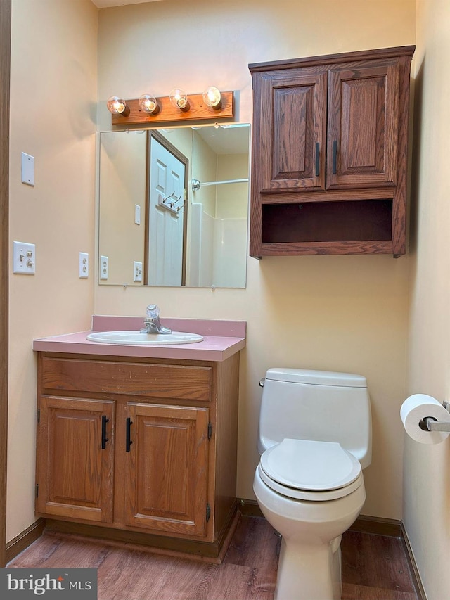 bathroom with vanity, hardwood / wood-style flooring, a shower, and toilet