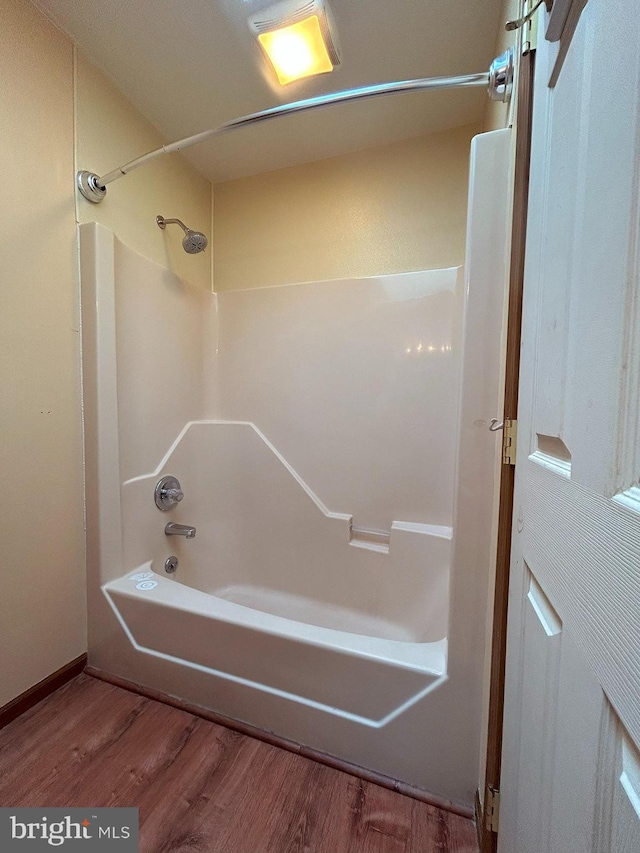 bathroom with bathing tub / shower combination and hardwood / wood-style floors