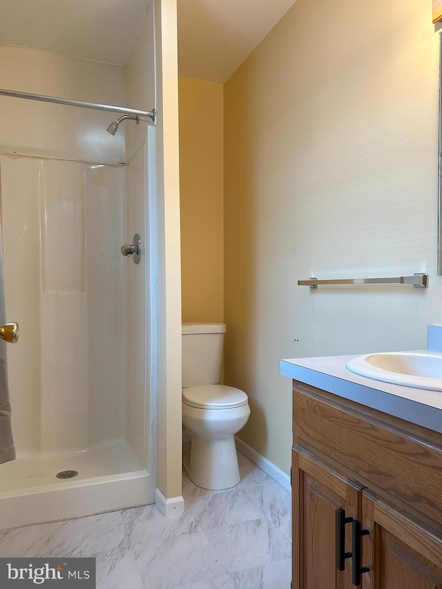 bathroom with vanity, toilet, and a shower