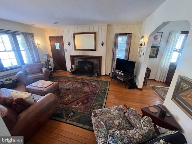 living room featuring hardwood / wood-style floors and wooden walls