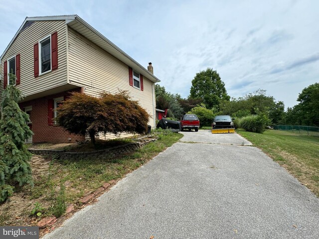 1941 Cedar Dr, Spring Grove, PA 17362 - view of side of home with driveway, a chimney, and brick siding
