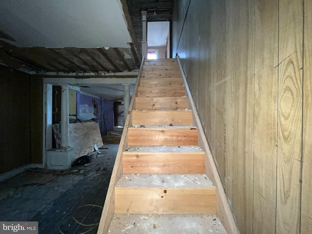 stairs featuring wood walls