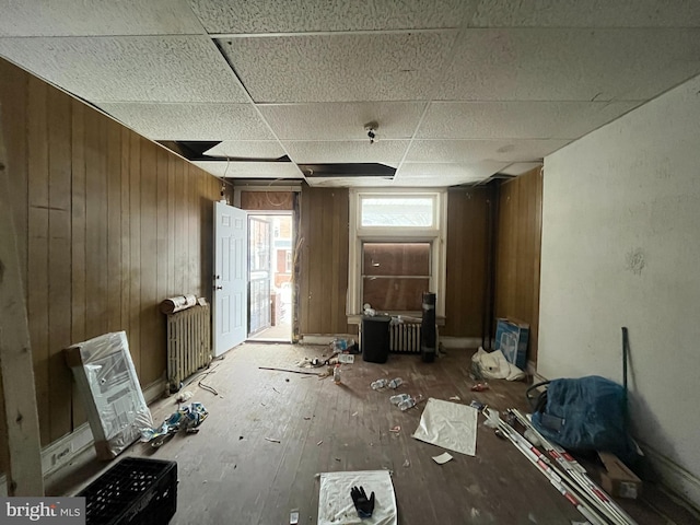 misc room featuring radiator heating unit and wood walls