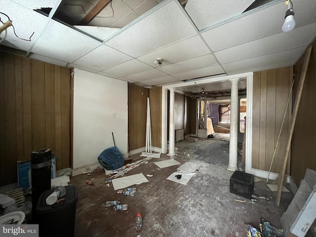 misc room with decorative columns, wood walls, and a paneled ceiling