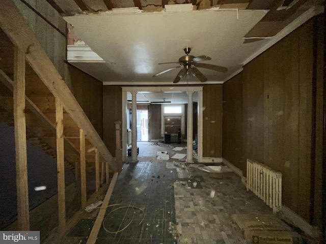 misc room with ceiling fan, radiator heating unit, ornate columns, and wooden walls