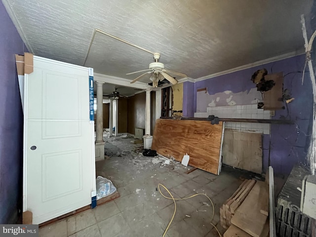 interior space with ornate columns, ceiling fan, and crown molding