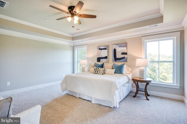 bedroom featuring ceiling fan, ornamental molding, a raised ceiling, and multiple windows