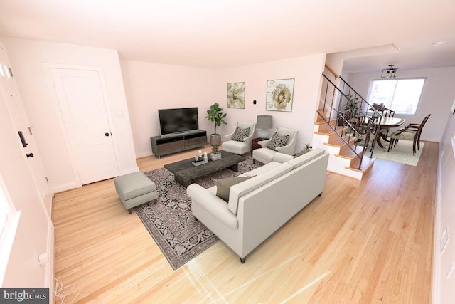 living area with light wood-style flooring, stairs, and baseboards