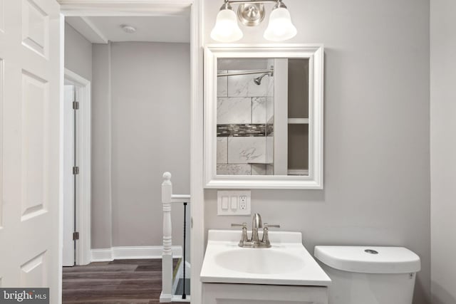 bathroom with hardwood / wood-style flooring, toilet, and vanity