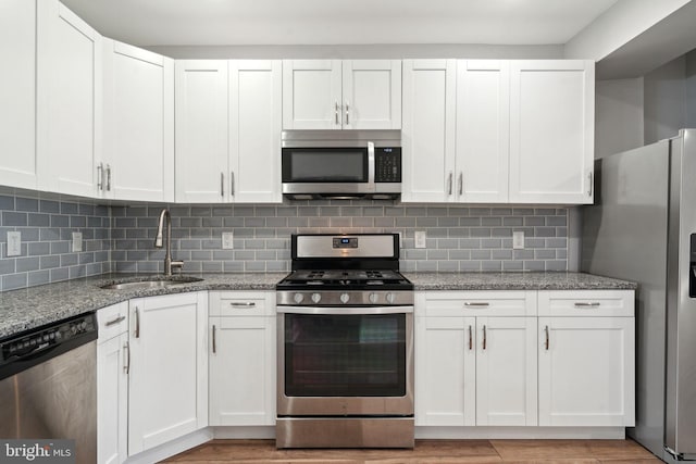 kitchen with sink, white cabinetry, appliances with stainless steel finishes, and decorative backsplash