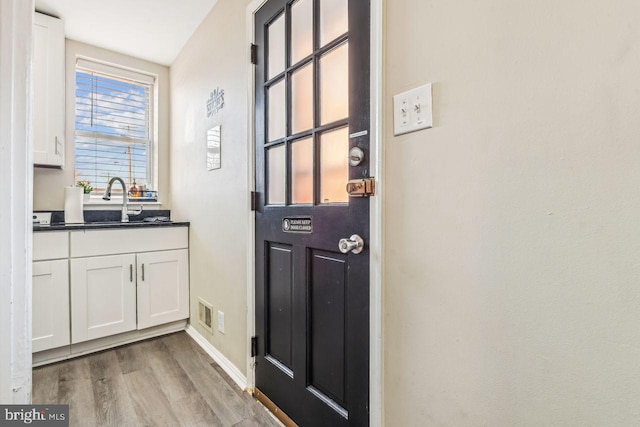 doorway featuring sink and light wood-type flooring