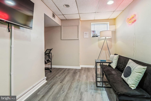 interior space featuring a paneled ceiling and hardwood / wood-style floors