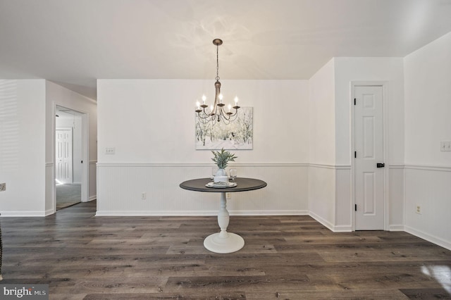 unfurnished dining area featuring dark hardwood / wood-style flooring and a notable chandelier