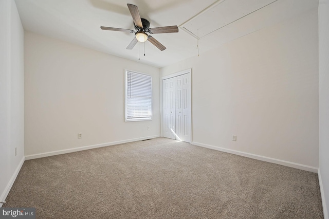 unfurnished room with ceiling fan and carpet