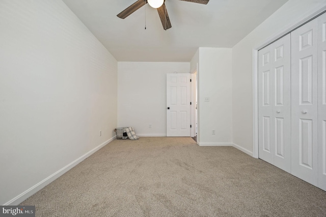 unfurnished bedroom featuring ceiling fan, light colored carpet, and a closet