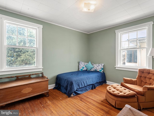 bedroom featuring ornamental molding and wood-type flooring