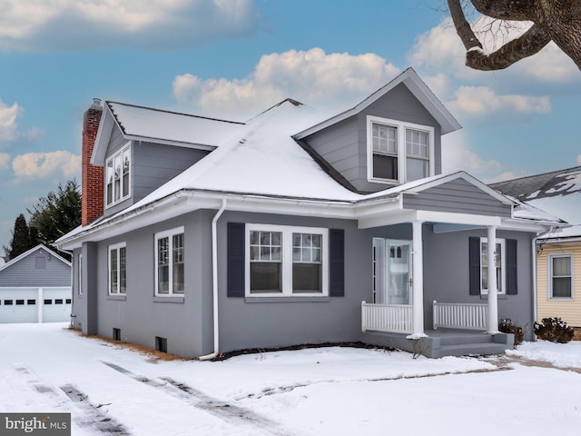 view of front facade featuring an outbuilding, a garage, and covered porch