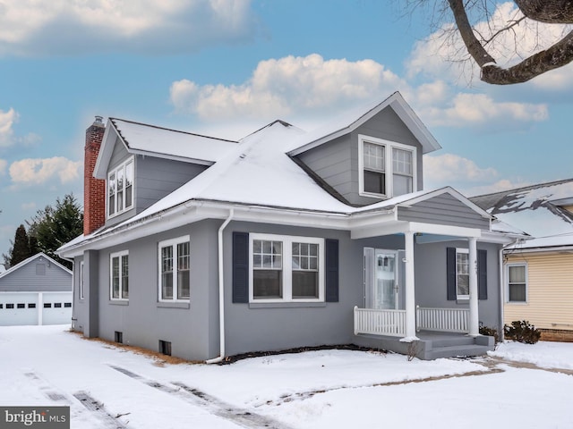 view of front of house featuring an outbuilding, a garage, and covered porch