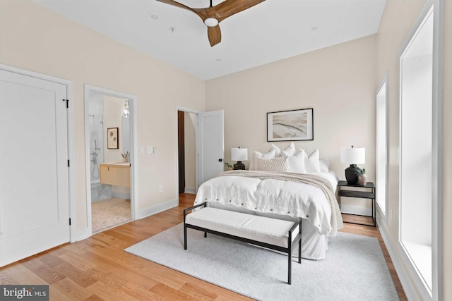 bedroom featuring ceiling fan, connected bathroom, and light hardwood / wood-style flooring