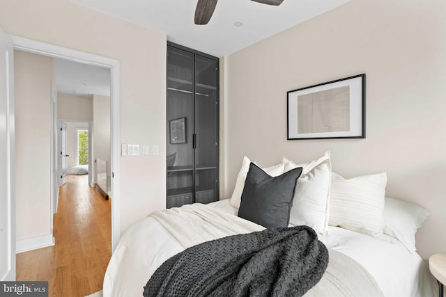 bedroom featuring light hardwood / wood-style flooring, a closet, and ceiling fan