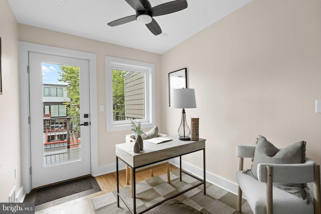 home office with ceiling fan and light hardwood / wood-style flooring