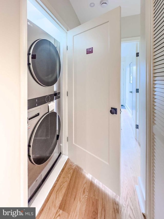 washroom featuring light hardwood / wood-style floors and stacked washer and dryer