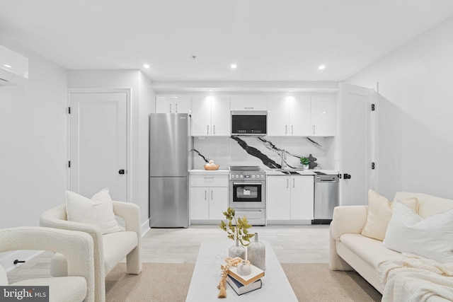 living room featuring light hardwood / wood-style floors, sink, and a wall mounted air conditioner