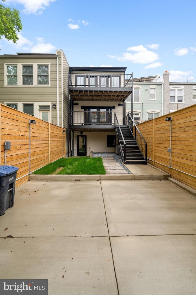 rear view of house featuring a balcony and a patio area