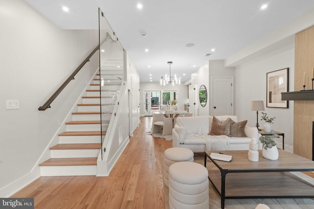 living room with light hardwood / wood-style floors and a notable chandelier