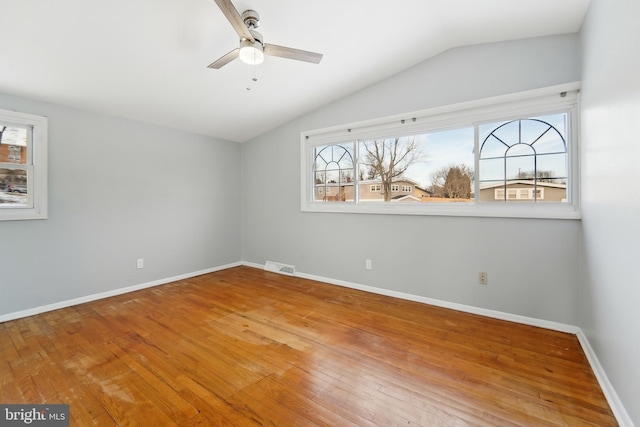 empty room featuring ceiling fan, hardwood / wood-style floors, and vaulted ceiling