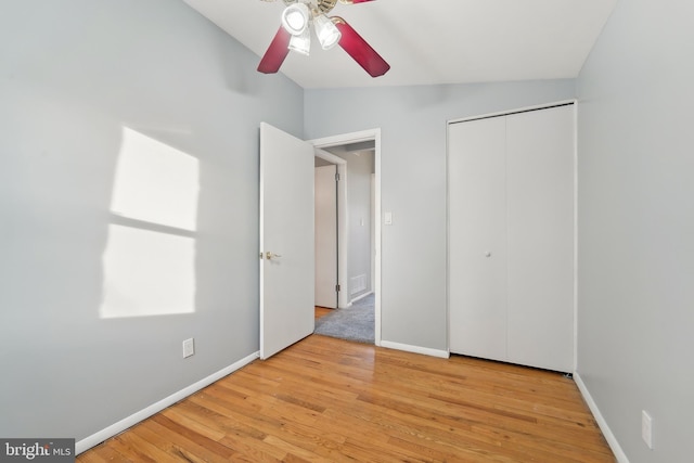 unfurnished bedroom with a closet, vaulted ceiling, ceiling fan, and light hardwood / wood-style floors