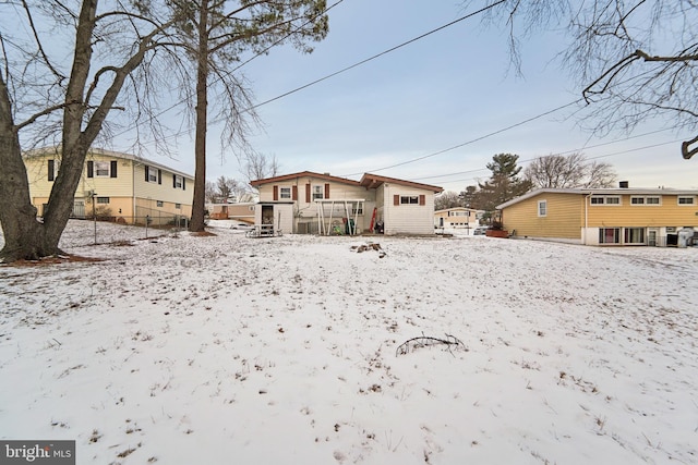 view of snow covered rear of property