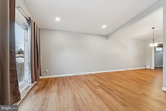 unfurnished room with light wood-type flooring and beam ceiling