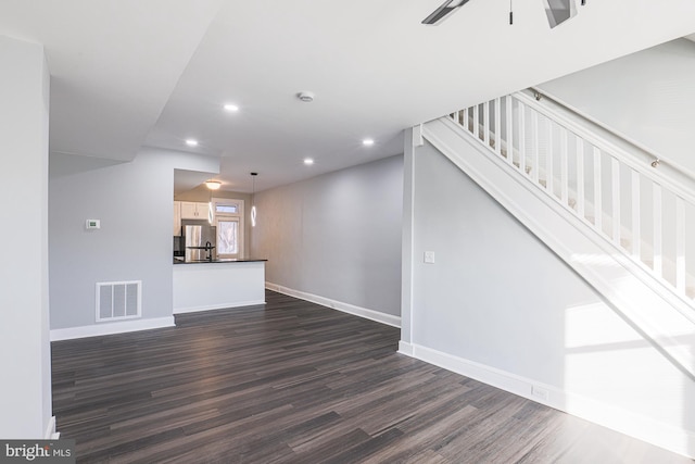 unfurnished living room featuring ceiling fan and dark hardwood / wood-style flooring