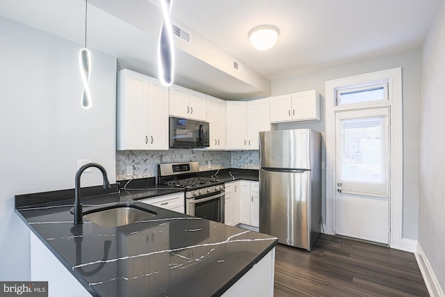 kitchen with sink, stainless steel appliances, white cabinets, decorative backsplash, and kitchen peninsula