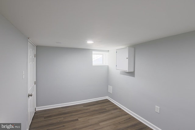 basement with dark hardwood / wood-style flooring