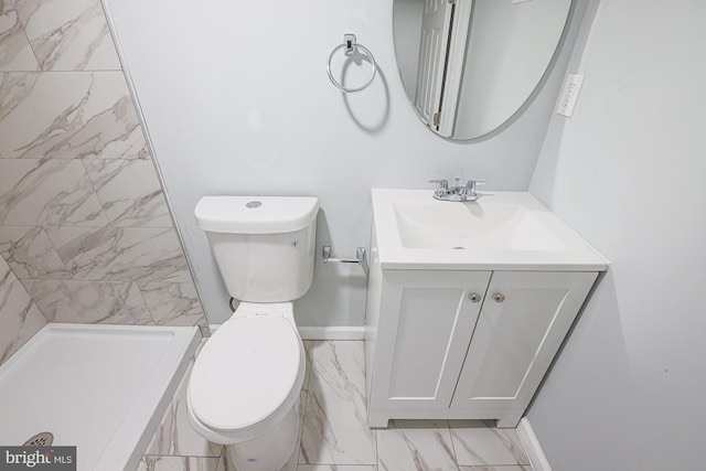 bathroom with vanity, toilet, and tiled shower