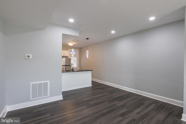 unfurnished living room with dark hardwood / wood-style floors and sink