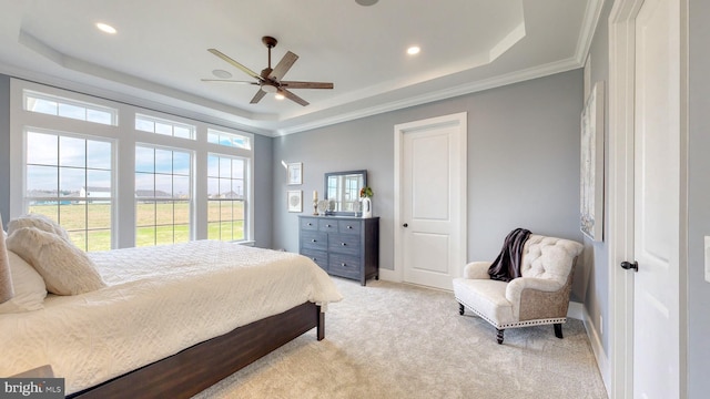 bedroom featuring ceiling fan, light colored carpet, crown molding, and a tray ceiling