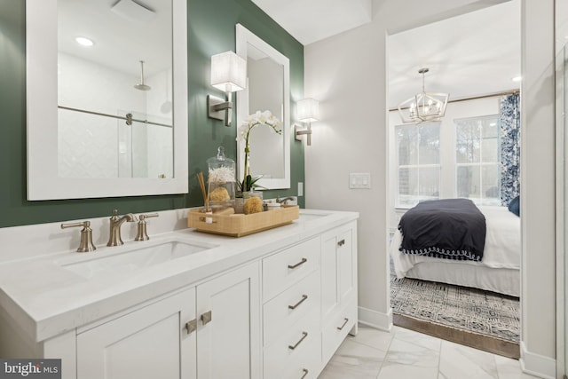 bathroom with a shower with door, a chandelier, and vanity