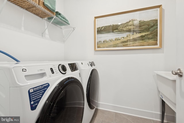 laundry area featuring light tile patterned flooring and washing machine and clothes dryer