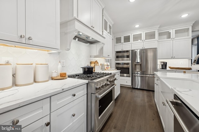 kitchen featuring dark hardwood / wood-style flooring, high quality appliances, backsplash, white cabinets, and light stone countertops